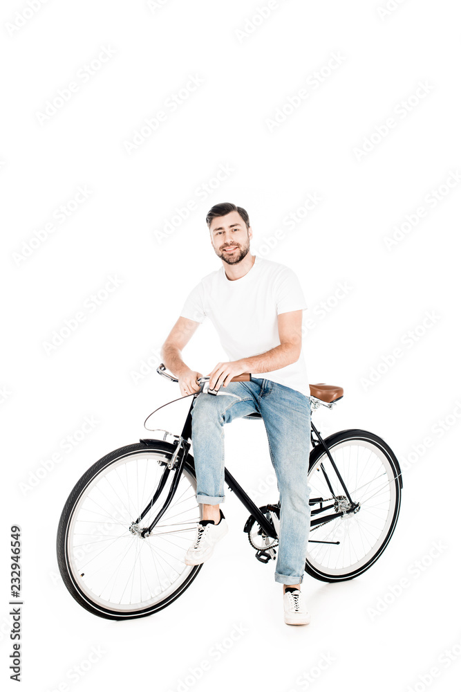 Handsome smiling man riding bicycle isolated on white Handsome smiling man riding bicycle isolated on white