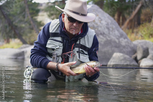 catching a Cutthroat trout by a fly fisherman photo