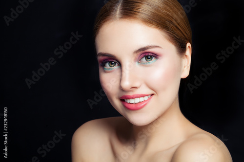 Portrait of cheerful woman with makeup on black