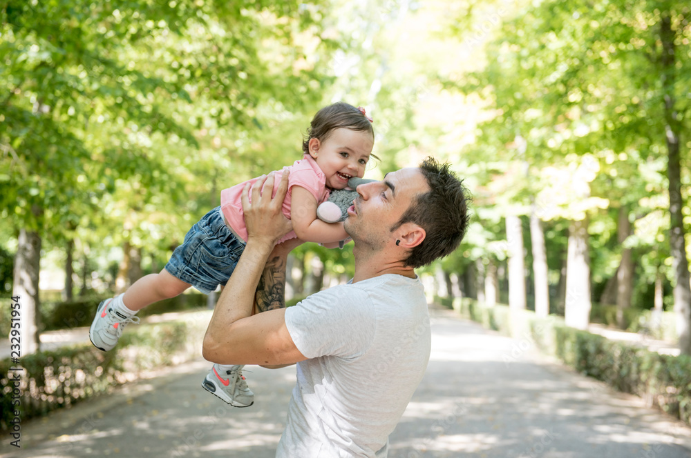 Fototapeta premium Beautiful baby in the park with her father