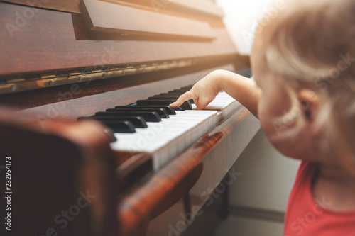music education - child pushing piano keys