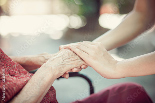 Hand of  eldery  woman with her caregiver at home. Home care or Elderly care concept.