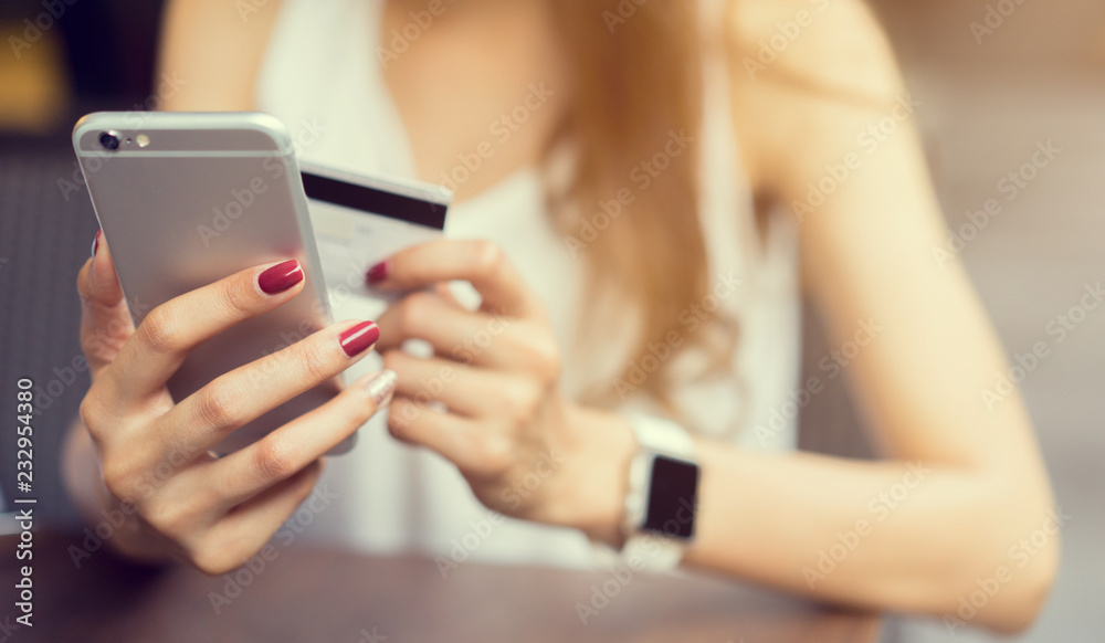 close up woman holding smartphone for shopping online and using credit card for payment in relaxing time