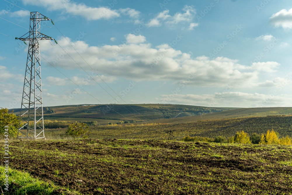 Meadow farm fields with highvoltage transmission lines and electricity