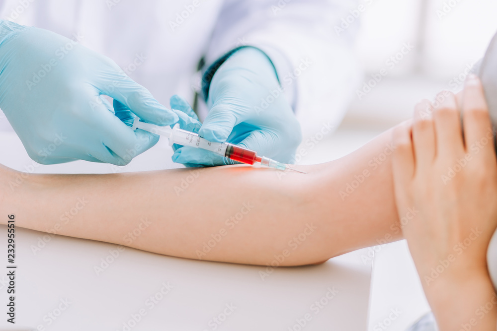 Close up Hand of nurse, doctor or Medical technologist in blue gloves taking blood sample from a patient in the hospital. Close up Hand of nurse, doctor or Medical technologist in blue gloves taking blood sample from a patient in the hospital.