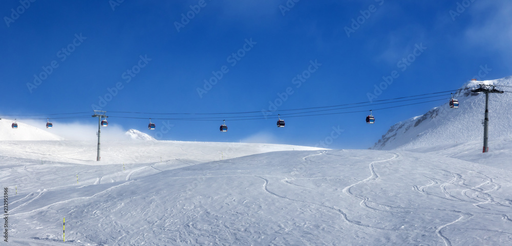 Panoramic view on gondola lift and off-piste ski slope in fog