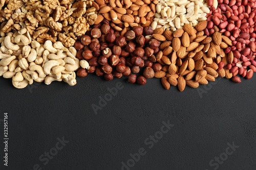 heaps of different nuts on a dark table