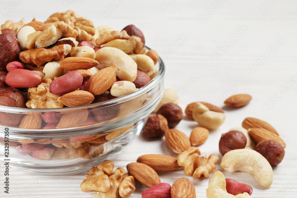 bowl with different mixed nuts on a white table bowl with different mixed nuts on a white table