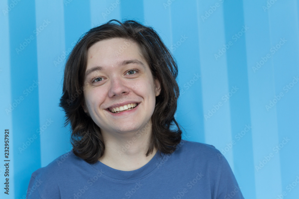 Portrait of Young man with long hair looking at camera. Teenage. Portrait of Young man with long hair looking at camera. Teenage.