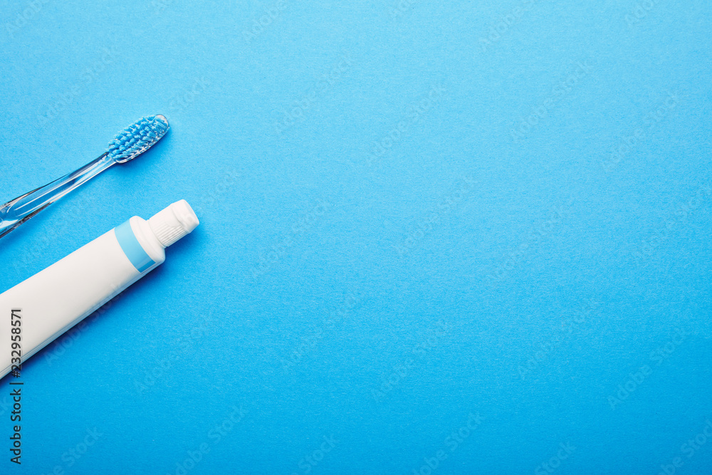 top view of toothbrush and toothpaste arranged on blue backdrop, dentistry concept top view of toothbrush and toothpaste arranged on blue backdrop, dentistry concept