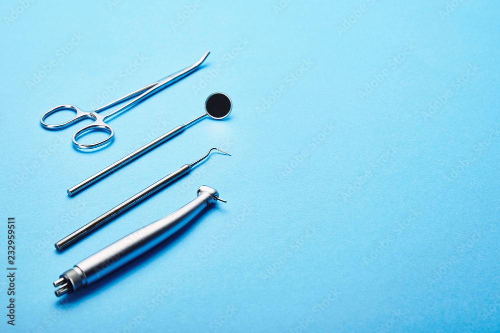 Fototapeta premium close up view of sterile stainless dental instruments on blue background