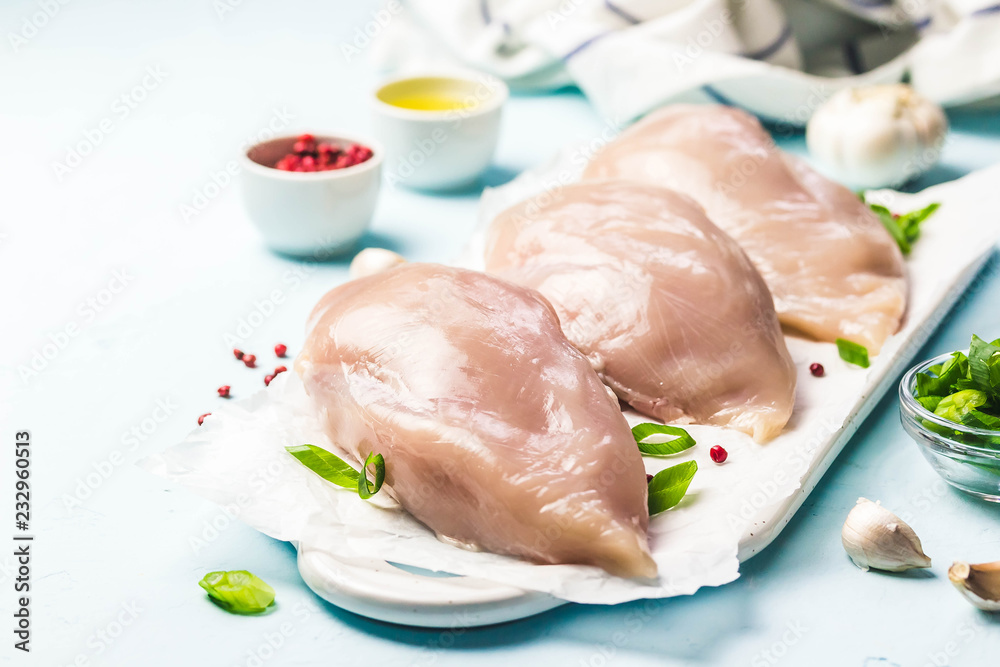 Chicken fillet on parchment paper, ready for cooking. Selective focus, space for text.