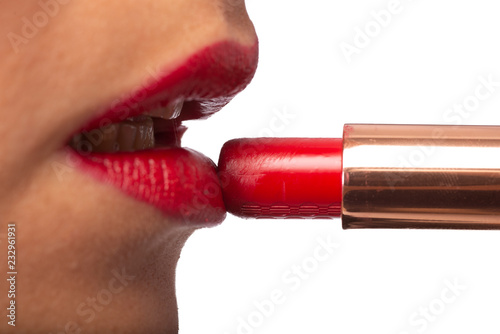 ragazza che applica il rossetto rosso sulle labbra  photo