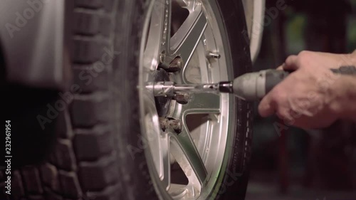 Tighten car tire nuts. Man using an impact wrench for tighten the nuts of car tire.4k,30fps.