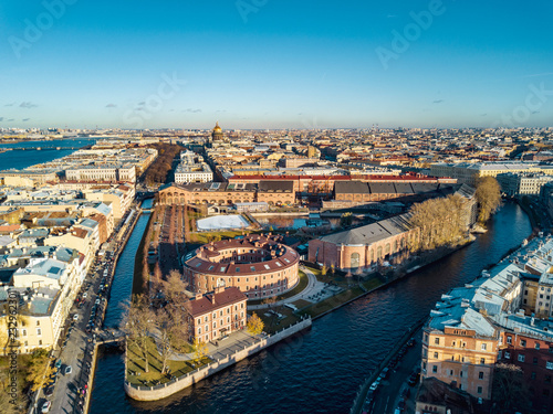 Aerial; drone panoramic view of Saint Petersburg cityscape; historical architecture, old building of royal times; usual picture of river channel and connected facades; sunny autumn day natural light