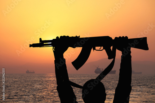 silhouette of machine gun in male hands