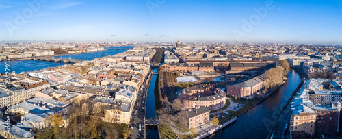 Aerial; drone panoramic view of Saint Petersburg cityscape; historical architecture, old building of royal times; usual picture of river channel and connected facades; sunny autumn day natural light