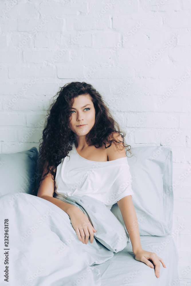 happy woman sitting in bed during morning time at home happy woman sitting in bed during morning time at home