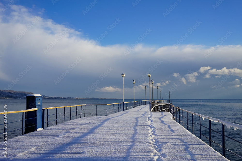 winter landscape with pier in the background of sea and sky.