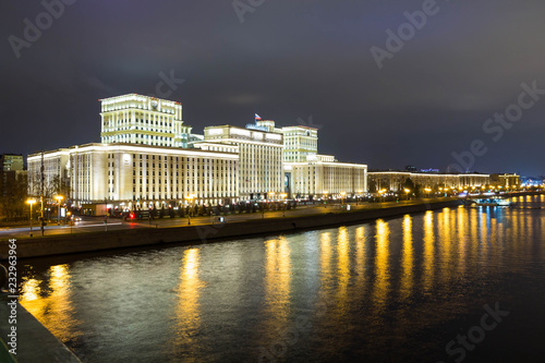 Beautiful building near the river on the background of the city with lights