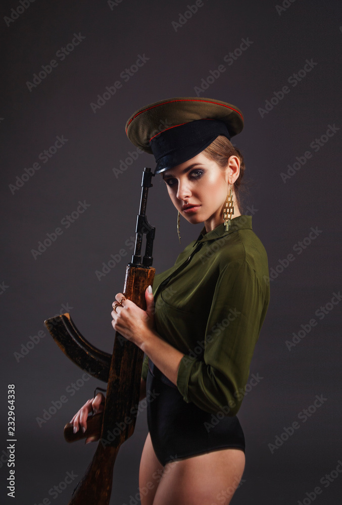 Sexy girl in military uniform with automatic