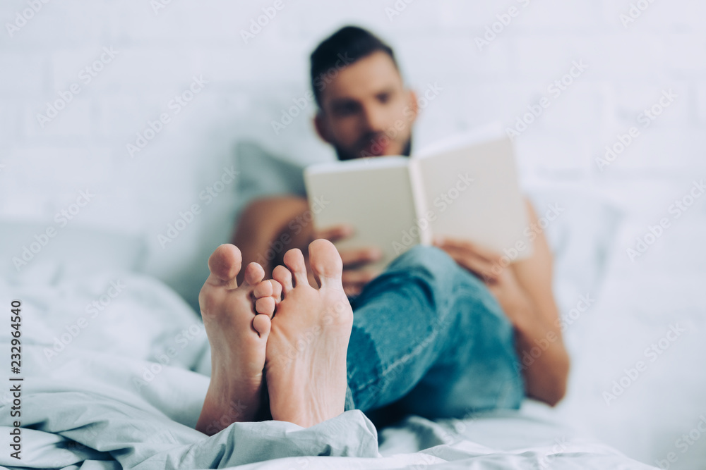 Obraz premium selective focus of man reading book in bedroom at home