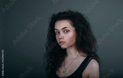 Portrait of a girl on a dark background in the studio