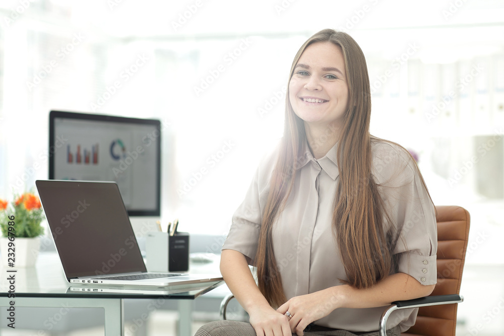 Close-up of young smiling businesswoman sitting at her workplace Close-up of young smiling businesswoman sitting at her workplace