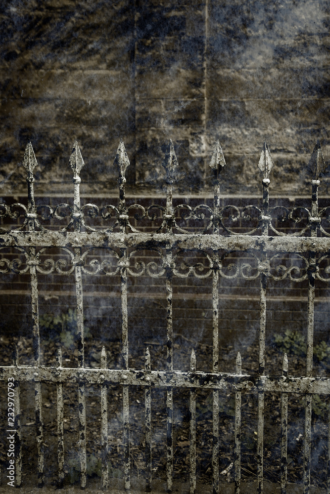 Old forged iron cast fence with sharp spears and cracked paint from time to time. White dirty abandoned fence that broke through the years of neglect. Stylized artwork vintage background for design