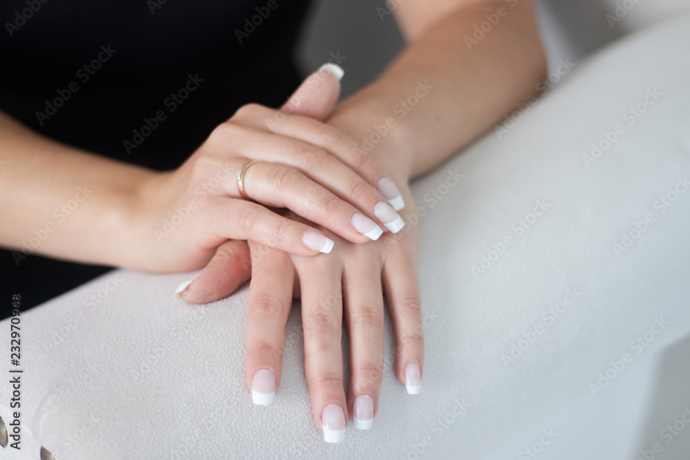 White manicure on the hands of a woman. Female manicure. False nails White manicure on the hands of a woman. Female manicure. False nails
