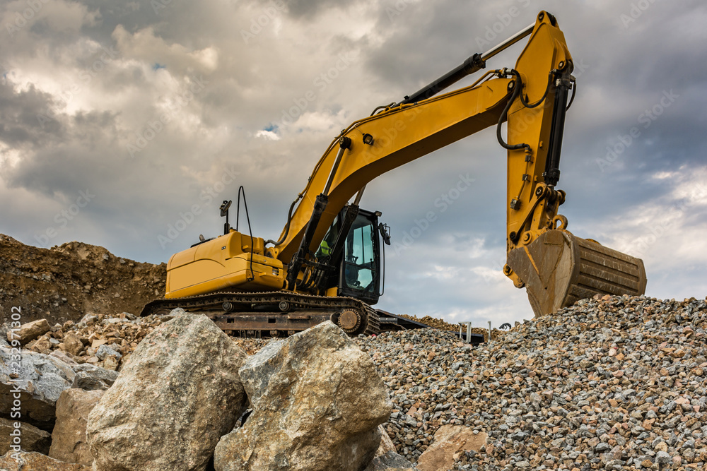 Large excavator in a quarry, the stone is transformed into gravel for the construction of a road Large excavator in a quarry, the stone is transformed into gravel for the construction of a road