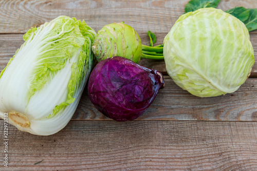 Several kinds of cabbage on rustic wooden table. Top view