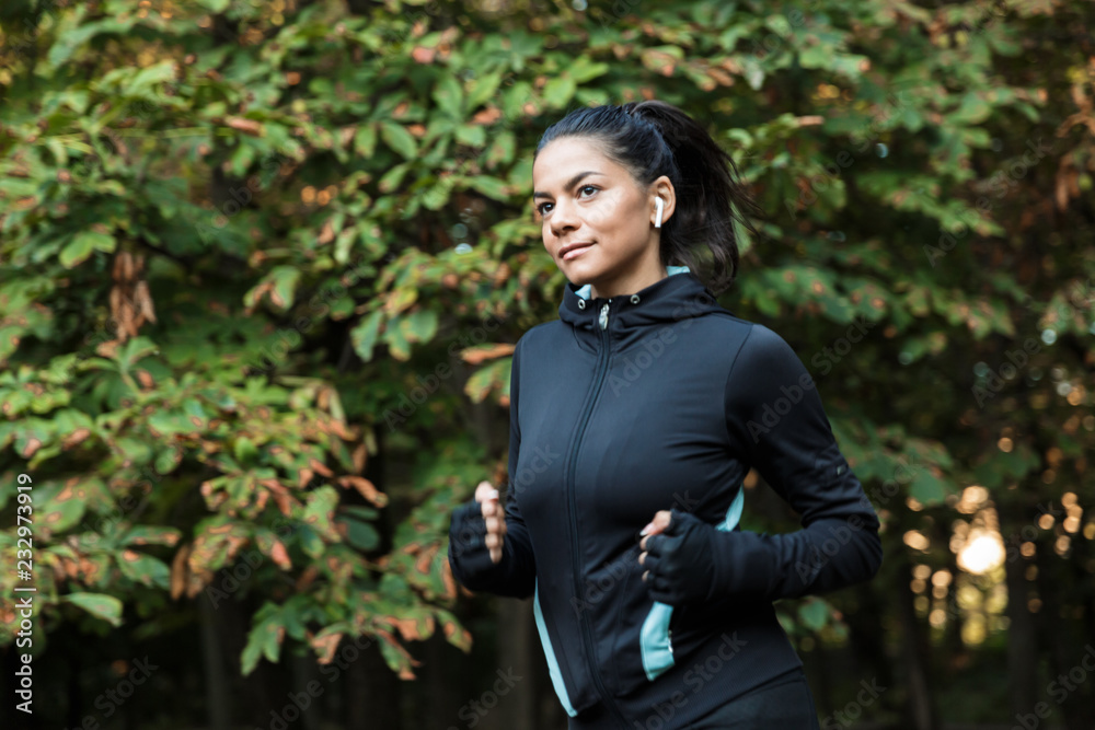 Smiling young fitness woman jogging at the park Smiling young fitness woman jogging at the park