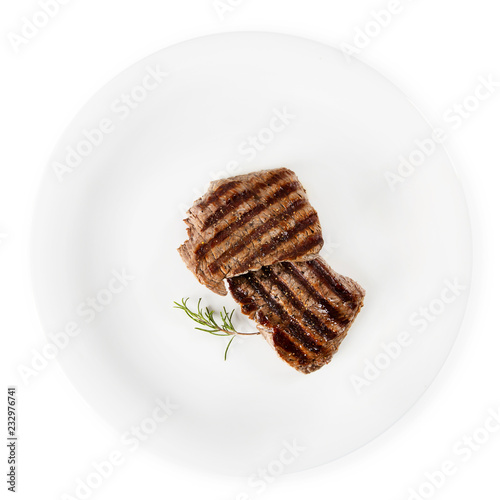 Two steaks and rosemary on a white background.
