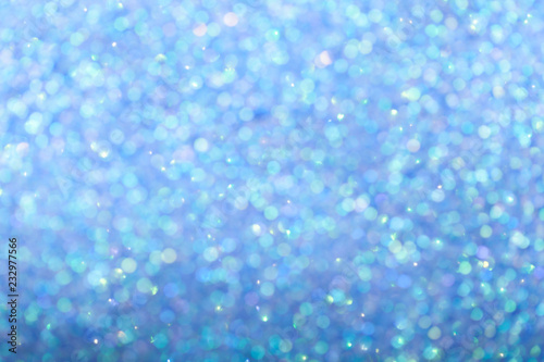 Blurred shiny blue background with sparkling lights.
