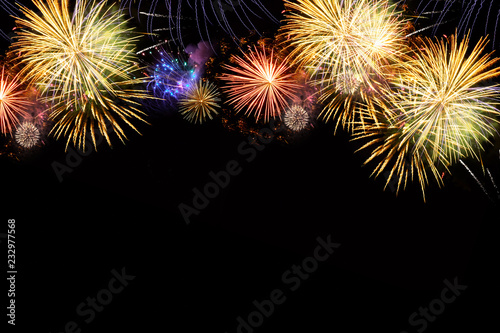 Fireworks colorful explosions border on black, festive background