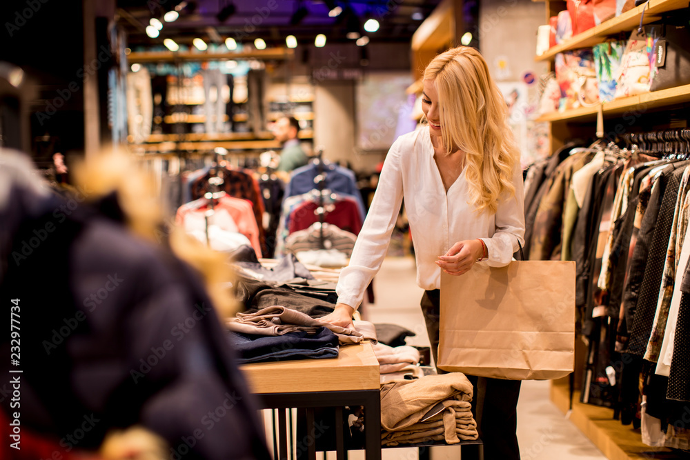 Young woman with shopping bags standing at the clothing store