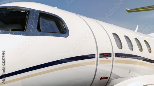 White VIP business jet cockpit windows and entrance door close up