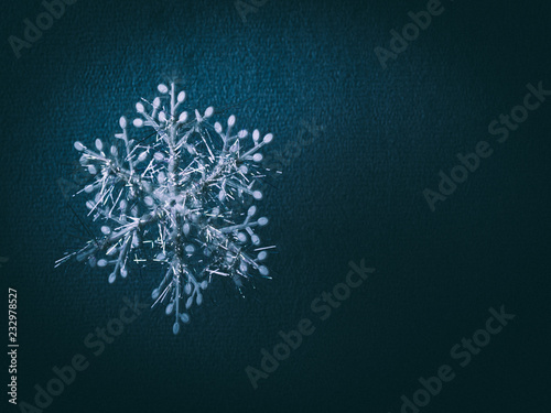 Decorative snowflake on the blue paper textured background