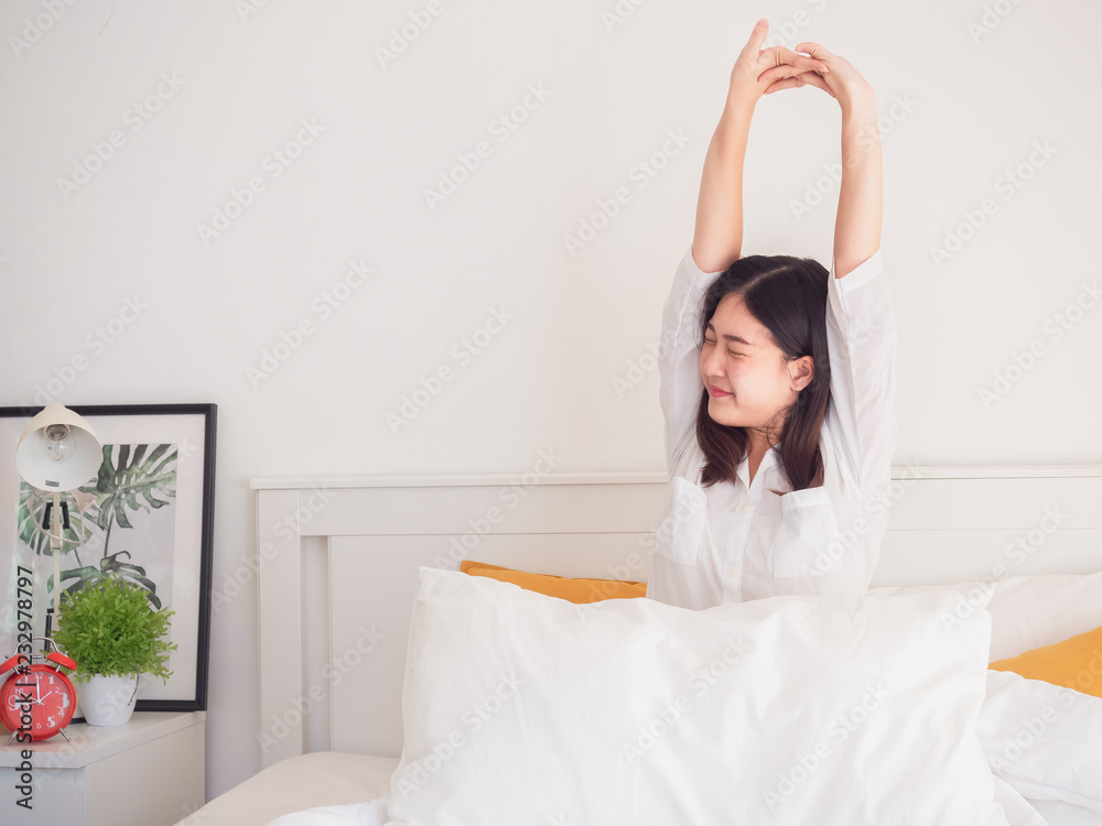 asian woman stretching in bed after wake up asian woman stretching in bed after wake up