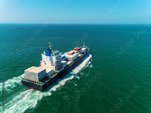 Container ship full speed with beautiful wave to sea port for logistics import  export or transportation concept background. © Pawinee