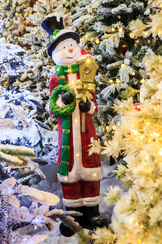 Decorative snowman figurine among Christmas tree