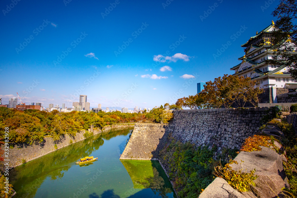 side view of osaka castle and urban skyline against beautiful clear blue sky