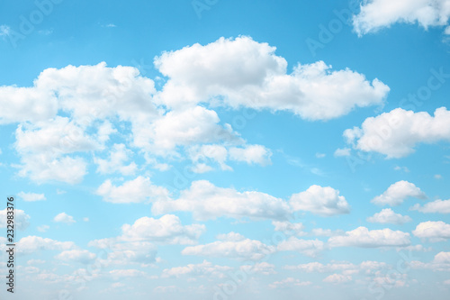 White Fluffy clouds in the light blue sky. Gradient Celestial Azure background.  © Julia Manga