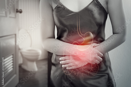Quadro su tela Asian woman in satin nightdress wake up for go to restroom, The photo of internal organs is on the women's body against toilet background, Healthcare and lifestyle concept