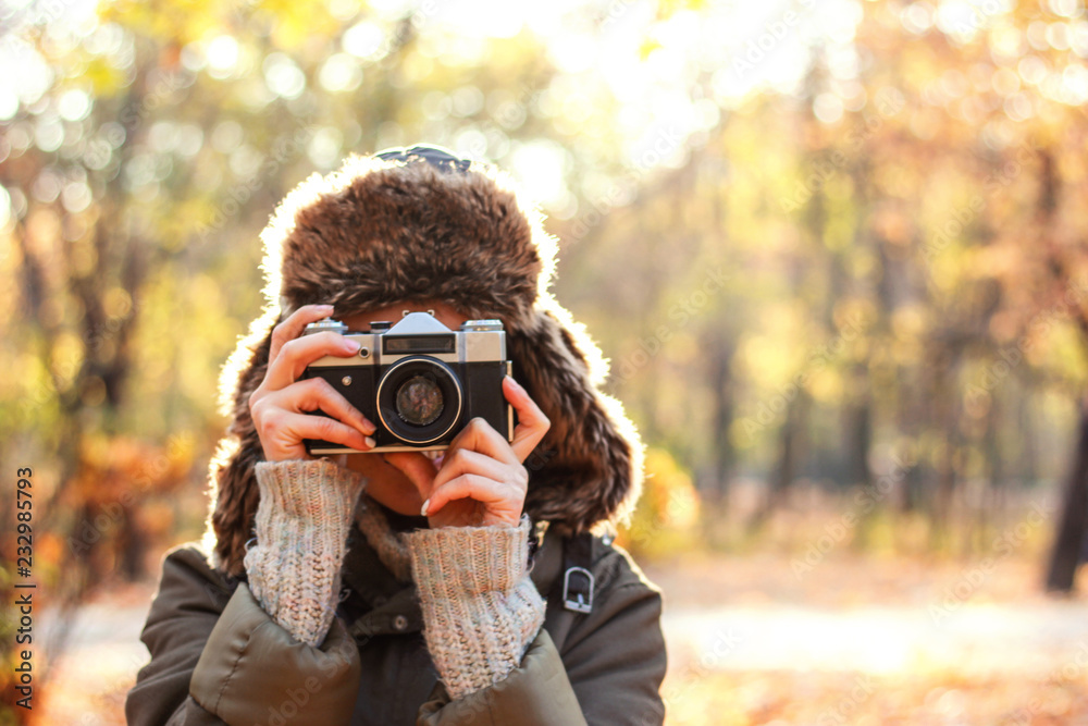 Young woman taking pictures in the autumn park. Concept girl photographer Young woman taking pictures in the autumn park. Concept girl photographer