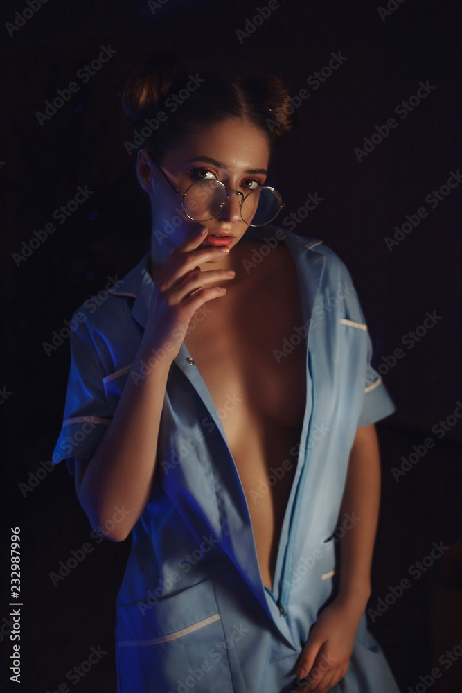 Obraz premium Sexy girl in nurse costume on dark background. Decollete model