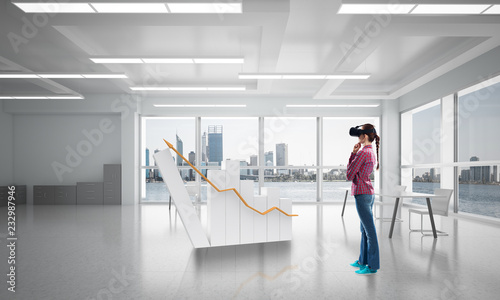 Girl in office interior in virtual reality mask using innovative technologies. Mixed media © adam121