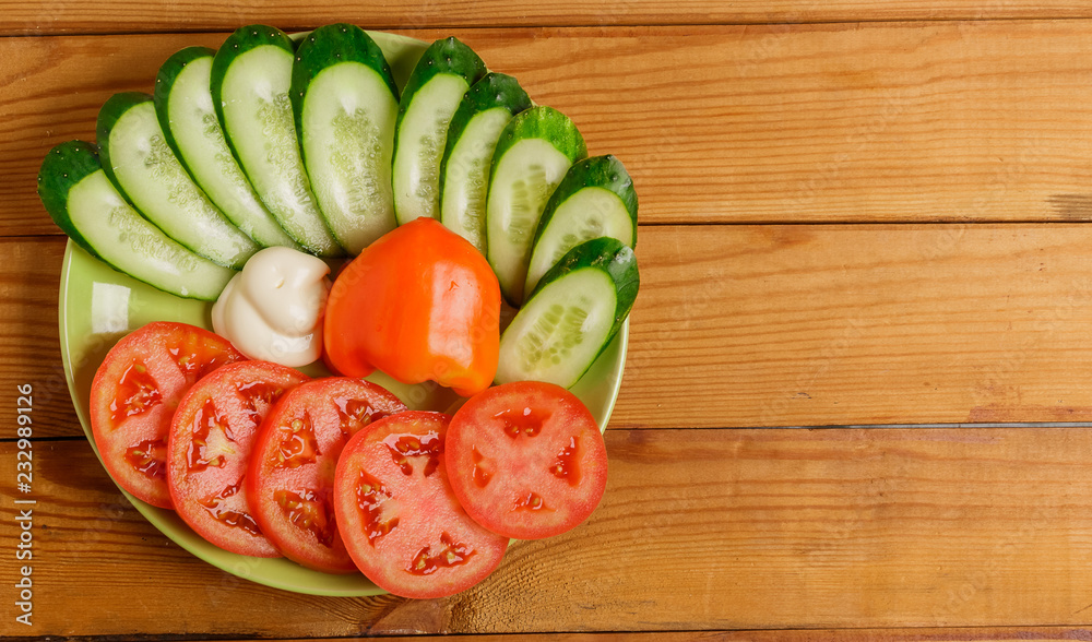 Cucumbers, tomatoes, peppers and sauce cut into pieces on a plate. Cucumbers, tomatoes, peppers and sauce cut into pieces on a plate.