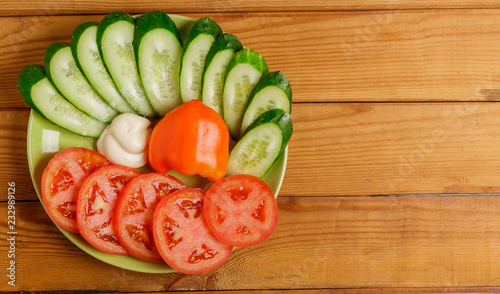 Cucumbers, tomatoes, peppers and sauce cut into pieces on a plate.